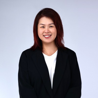 Professional headshot of a smiling woman with red hair, named Jennifer Loh Drysdale-Banks, wearing a black blazer and white shirt against a light grey background.