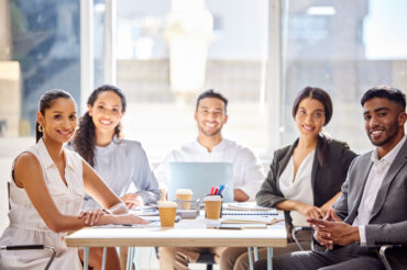 Five happy culturally-diverse employees in a meeting