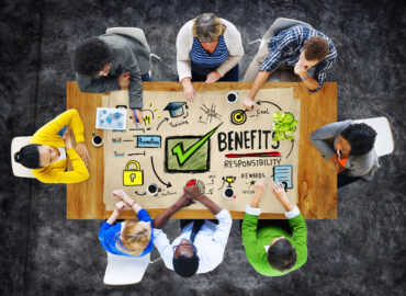 Group of corporate insurance brokers discussing employee benefits in singapore and responsibilities around a conference table with notes and diagrams.