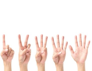 A group of hands displaying the octopus sign for medical benefits Singapore.